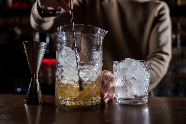 Barman hacer cóctel de alcohol en barra de bar. Barman haciendo cóctel de jugo de la selva en el bar