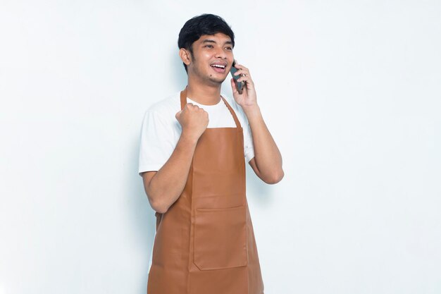 Bárman ou garçonete jovem barista asiático feliz e alegre usando smartphone móvel isolado no branco