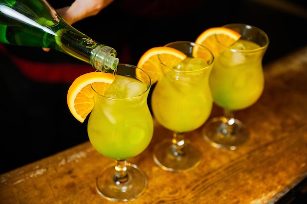 Barman prepara coquetéis alcoólicos no balcão do bar