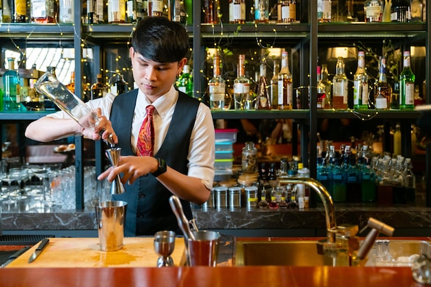 Barman profesional preparando y sirviendo cócteles al cliente en el mostrador de la barra en un club nocturno de lujo Barman haciendo bebidas alcohólicas mixtas para celebrar la fiesta de vacaciones en el bar del restaurante