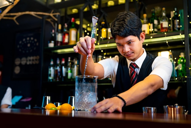 Barman profesional preparando y sirviendo cócteles al cliente en el mostrador de la barra en un club nocturno de lujo Barman haciendo bebidas alcohólicas mixtas para celebrar la fiesta de vacaciones en el bar del restaurante