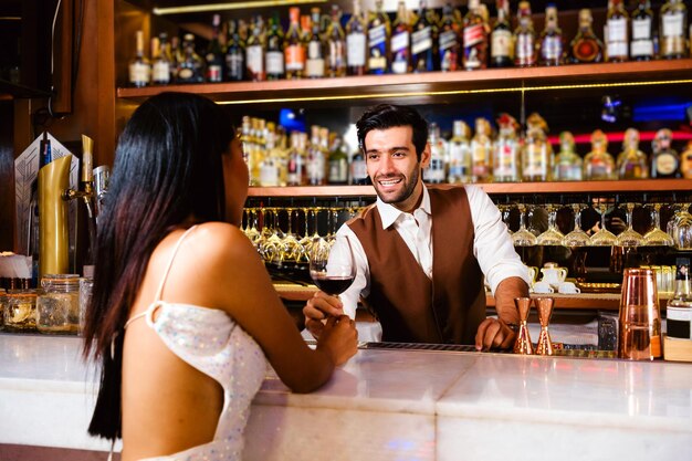 Barman profissional caucasiano ou mixologista fazendo um coquetel para mulheres em um bar