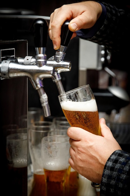 Barman serve cerveja em um copo.