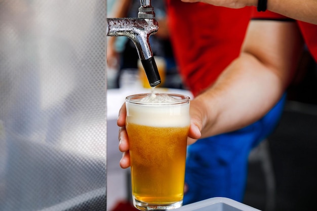 Foto barman servindo uma cerveja recém-vertida em um copo