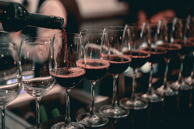 Barman servindo vinho tinto em uma taça de vinho. Restaurante, bebida, conceito de bebida alcoólica.