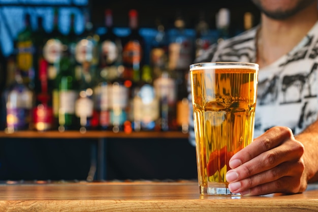 Barman sirve un vaso de cerveza fría en el mostrador del bar en el pub