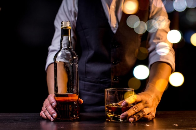 Barman sirviendo whisky vaso de whisky hermosa noche