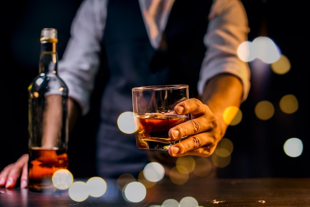 Barman sirviendo whisky vaso de whisky hermosa noche