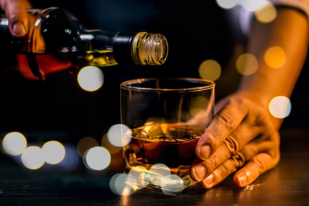 Barman sirviendo whisky vaso de whisky hermosa noche