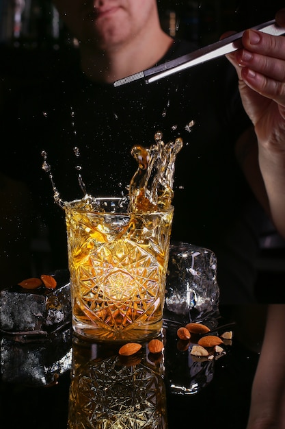Barman soltar cubo de gelo em bebida