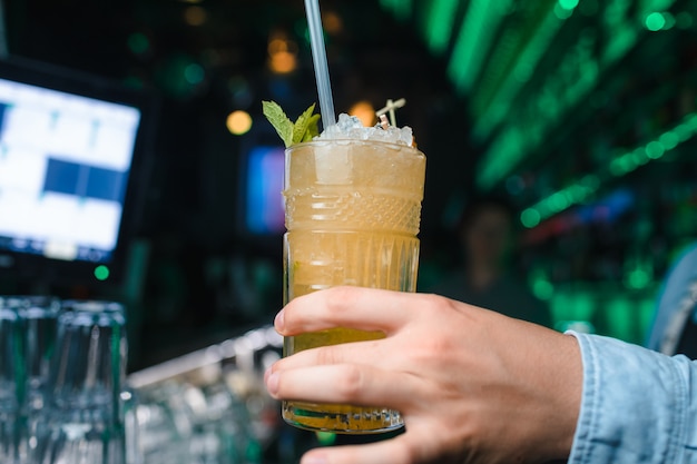 Barman tiene cóctel con menta en la mano. No cara. Enfoque selectivo