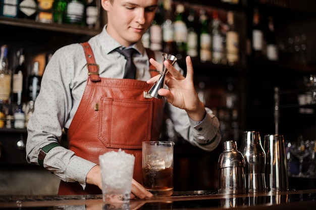 Barman vertiendo cóctel en un vaso