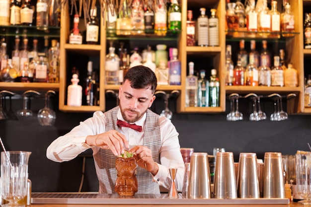 Barmann bereitet liebevoll einen Cocktail für seine Kunden zu. Konzept-Lifestyle-Nachtleben-Drinks