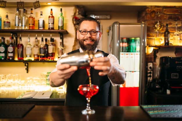 Barmann macht Alkoholcocktail an der Theke