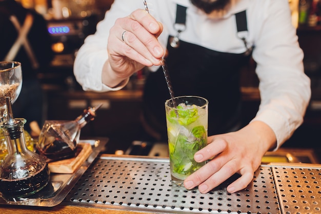 Barmann macht einen Cocktail an der Bar im Restaurant.