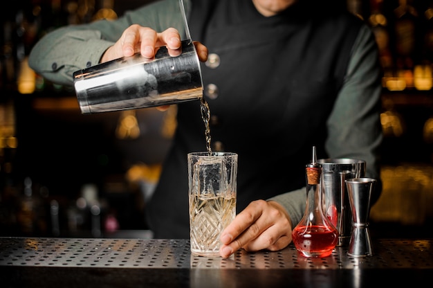 Barmen fazendo cocktail no balcão do bar