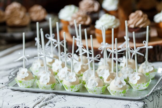 Barra de caramelo en banquete de boda de madera con una gran cantidad de diferentes dulces cupcakes soufflé y tortas