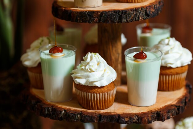 Barra de caramelo en banquete de boda de madera con una gran cantidad de diferentes dulces cupcakes soufflé y tortas