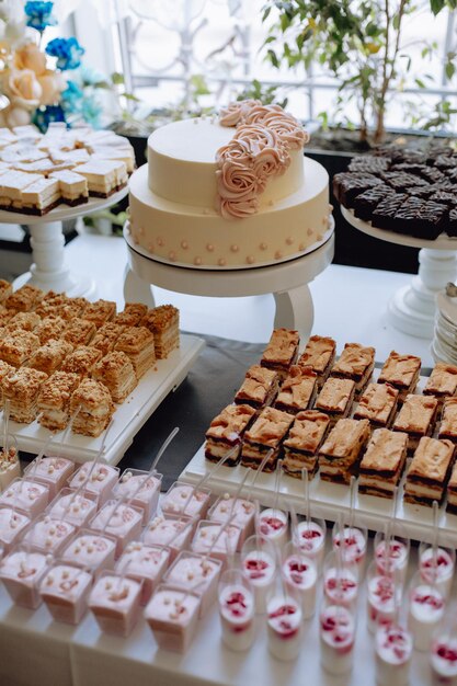 Barra de caramelo Pastel de bodas blanco decorado con flores de pie de mesa festiva