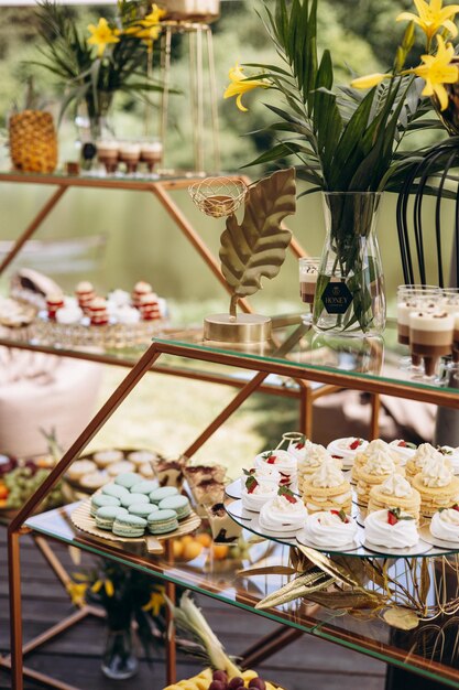 Foto una barra de caramelos con deliciosos postres en una boda