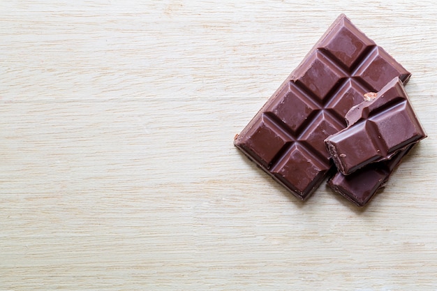 Barra de chocolate partido en la mesa de madera