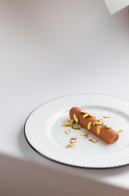 Barra de chocolate con relleno de leche y crema en un plato sobre un fondo claro