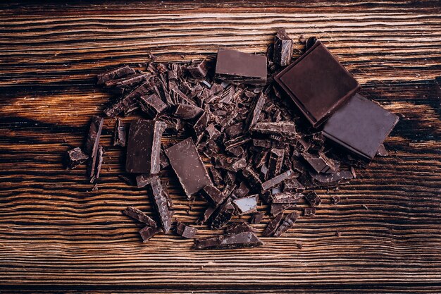 Foto barra de chocolate tajada en fondo de madera de la tabla.