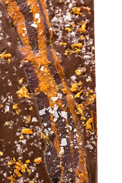 Barra de chocolate con tocino danamites gourmet sobre un fondo blanco.