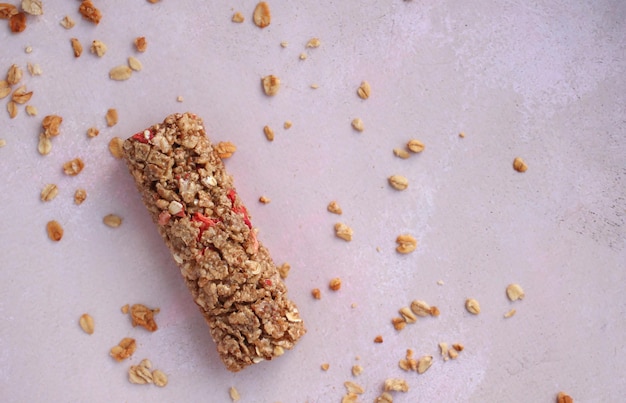 Barra de cereal saudável com granola em um fundo de pinklilac