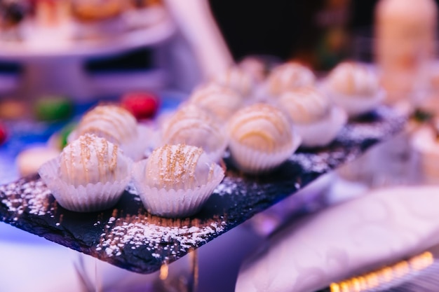 Barra de chocolate doce na celebração Bolo branco em um prato perto da vitrine com creme delicado no topo