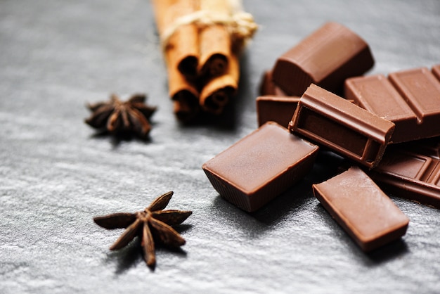 Barra de chocolate e especiarias em fundo escuro doce sobremesa doce para lanche