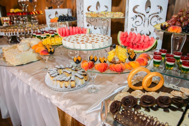 Barra de chocolate na recepção do casamento Bolos doces e frutas na mesa