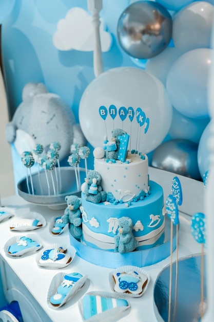 Foto barra de doces tema de aniversário de bebê com ursinho de pelúcia decoração de fundo festivo com letras de bolo dizendo um e balões azuis brancos no estúdio