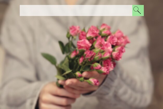 barra de pesquisa no fundo do buquê borrado de arbusto de rosas em mãos femininas