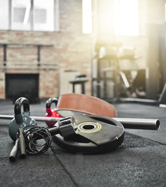 Barra desmontada, medicine ball, kettlebell, haltere, pular corda deitada no chão no ginásio. equipamento desportivo para treino com peso livre. treino funcional