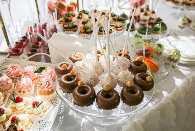 Barra de dulces en la recepción de la boda Cake pops y donas Hermosas decoraciones