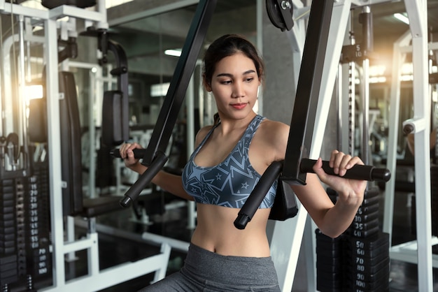 Barra de elevación de la mujer asiática joven en gimnasio. Concepto de motivación de estilo de vida saludable y entrenamiento.