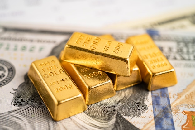 Barra de oro en billetes de dólar estadounidense dinero y gráfico economía finanzas intercambio comercio inversión concepto