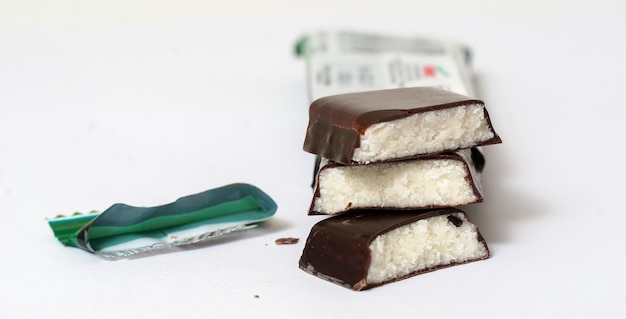 Foto barra de proteína de chocolate rellena con salsa de chocolate cortada sobre un fondo blanco