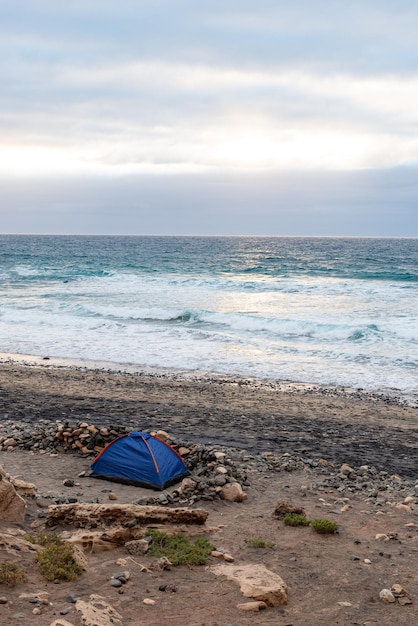 Foto barraca azul em uma praia ao pôr do sol timefuerteventuracanary islandimagem vertical