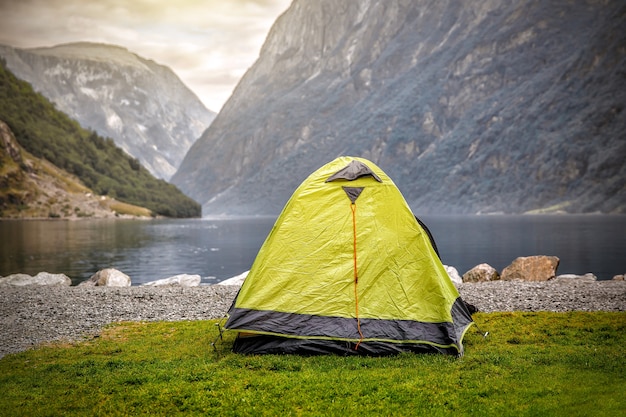 Barraca de acampamento em um belo fiorde selvagem, às margens de um lago com cordilheira ao fundo - acampamento na Noruega