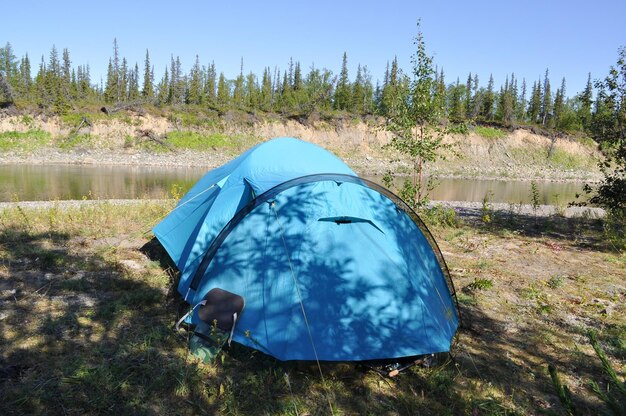 Barraca de acampamento na margem de um rio de montanha