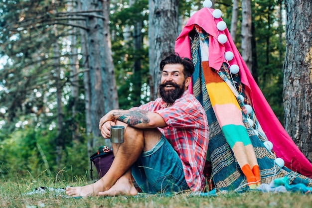 Barraca de acampamento no dia ensolarado homem barbudo no turismo de cabana descansar na natureza verão acampar na natureza