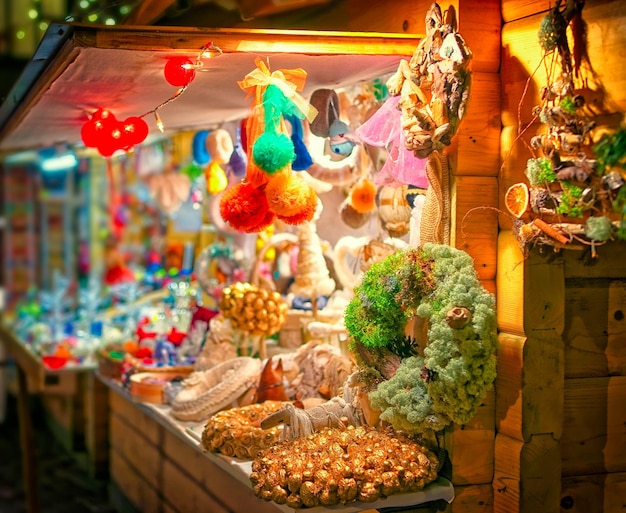 Barraca do mercado de natal à noite riga letônia. na europa no inverno. rua alemã natal e feira de férias na cidade ou vila europeia. decoração do advento e barracas com itens de artesanato no bazaar