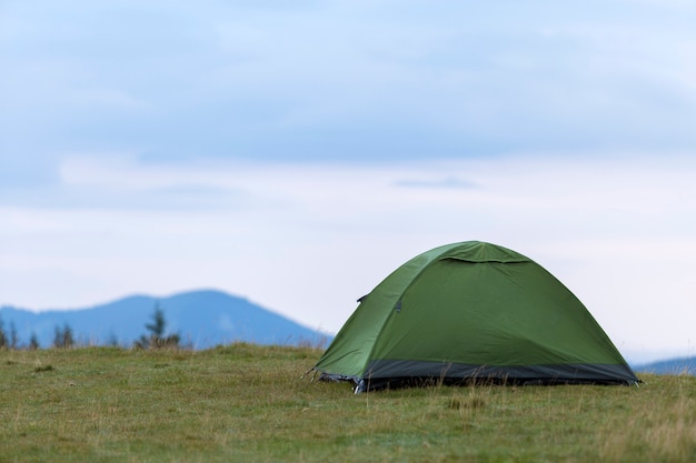 Barraca pequena do turista no monte gramíneo da montanha.