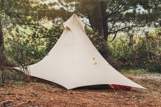 Barraca ultraleve com laços de corda é instalada em uma floresta densa no acampamento Atividade de fim de semana e equipamentos e equipamentos para caminhadas ou trekking