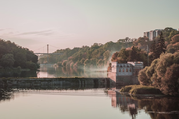 Barragem no rio com construção e ponte ao fundo