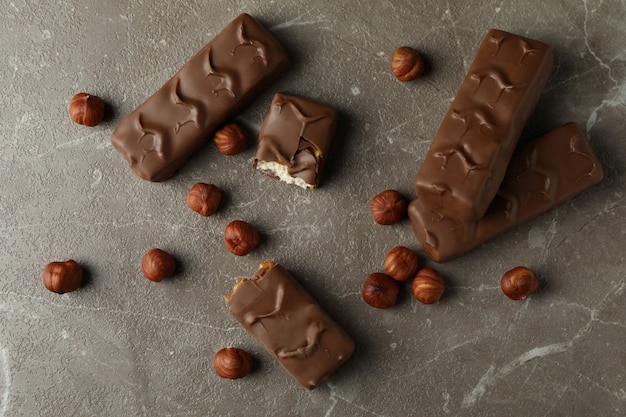 Barras de caramelo y nueces en mesa con textura gris