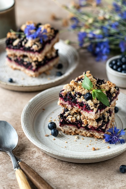 Barras caseras de crumble de arándanos decoradas con menta para el desayuno con decoración de flores de maíz