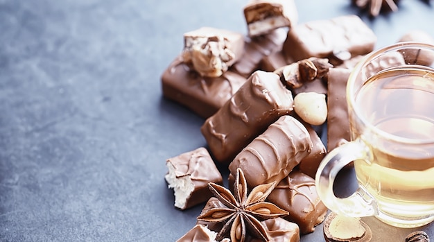 Barras de chocolate sobre un fondo negro a contraluz. Chocolate con relleno. Dulces dulces para merienda y té.